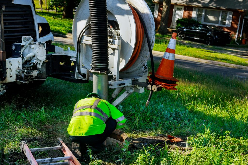 Trusted Best Sump Pump, Water Heater, and Garbage Disposal Service & Repair in Northeast Indiana | Best Sewer Line Cleaning, Repair, and Replacement in Northeast Indiana | Sewage cleaning workers equipment with sewer on a town street on industrial truck